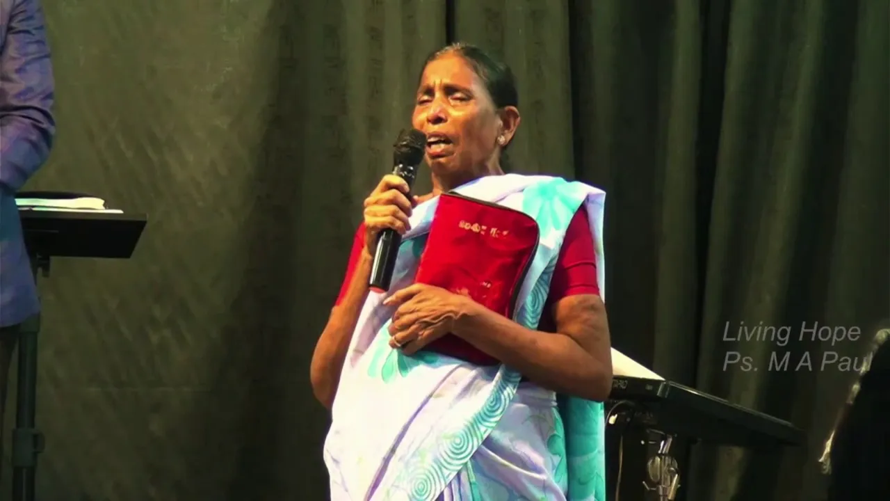 Mary sharing her testimony at Living Hope Church, holding a microphone and her Bible